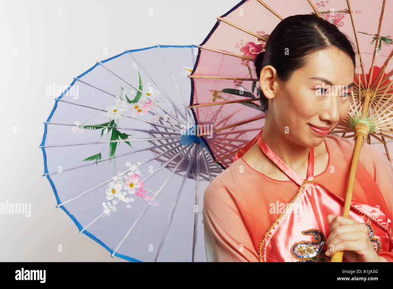 Close-up of a Mid adult woman holding des parapluies et souriant Banque D'Images