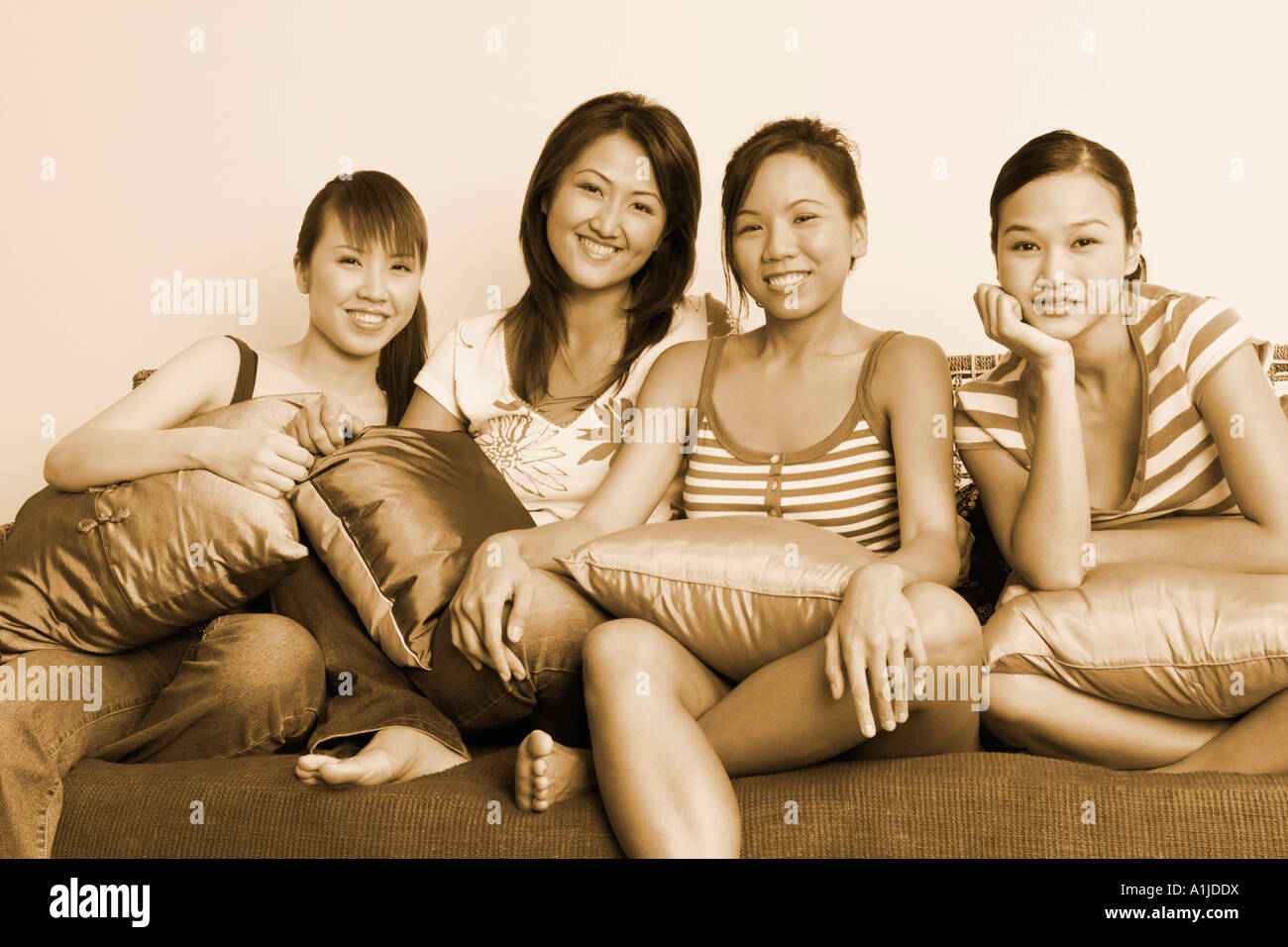 Portrait de quatre jeunes femmes assises sur un canapé et souriant Banque D'Images