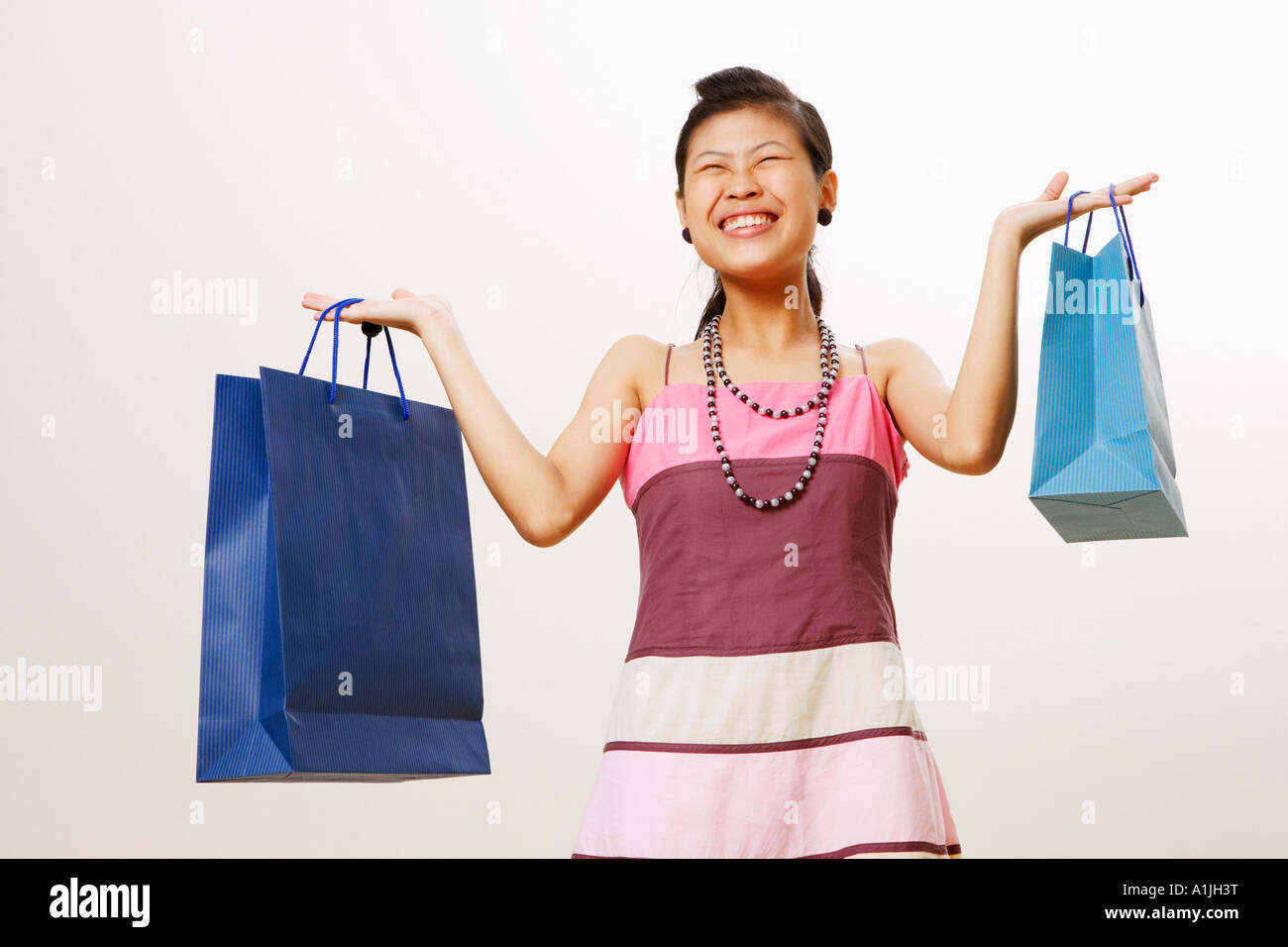 Young woman holding shopping bags avec ses yeux fermés Banque D'Images