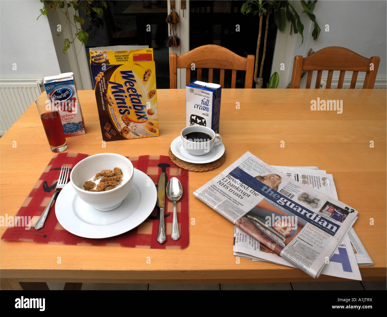 Table de petit déjeuner avec des paquets et de journaux Banque D'Images