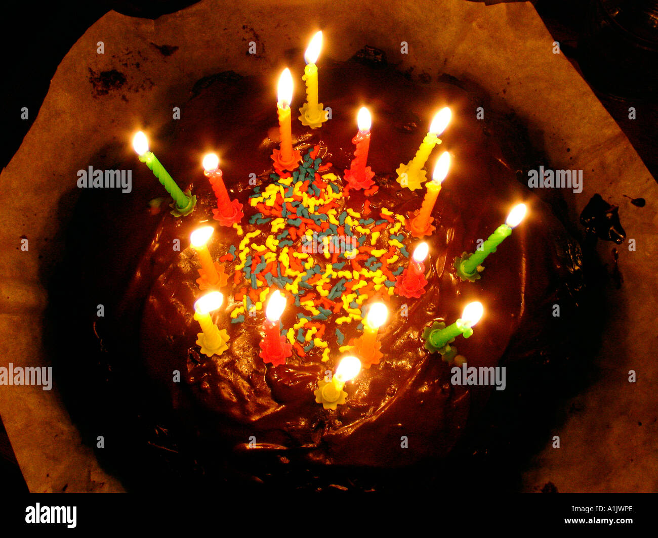 Anniversaire décoration gâteau au chocolat avec une éponge de ponçage et saupoudre de sucre coloré allumé des bougies Banque D'Images