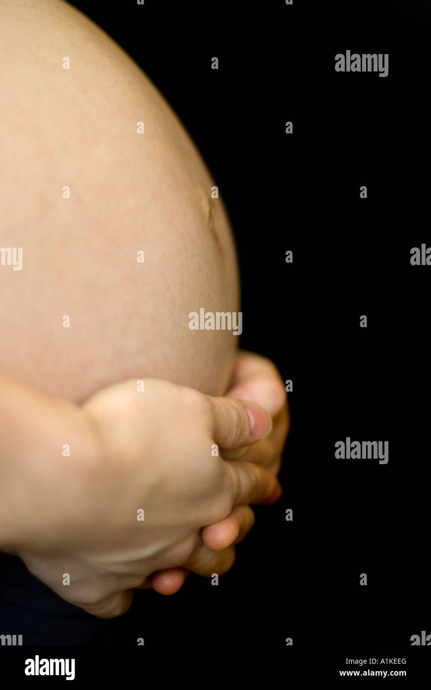 Saigner un ventre enceinte 38 semaines fond noir Banque D'Images