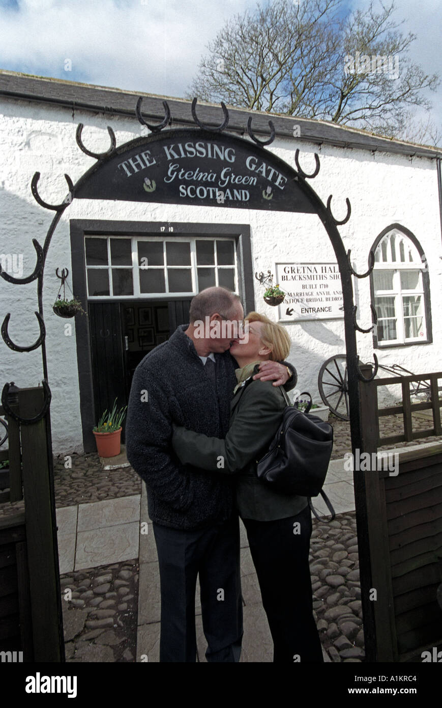 En vertu de la couple kissing Gate après leur mariage l'Ecosse Gretna Green Banque D'Images