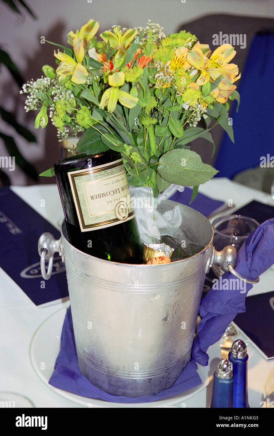 Bouteille de champagne vide avec bouquet de fleurs en metal bucket Banque D'Images
