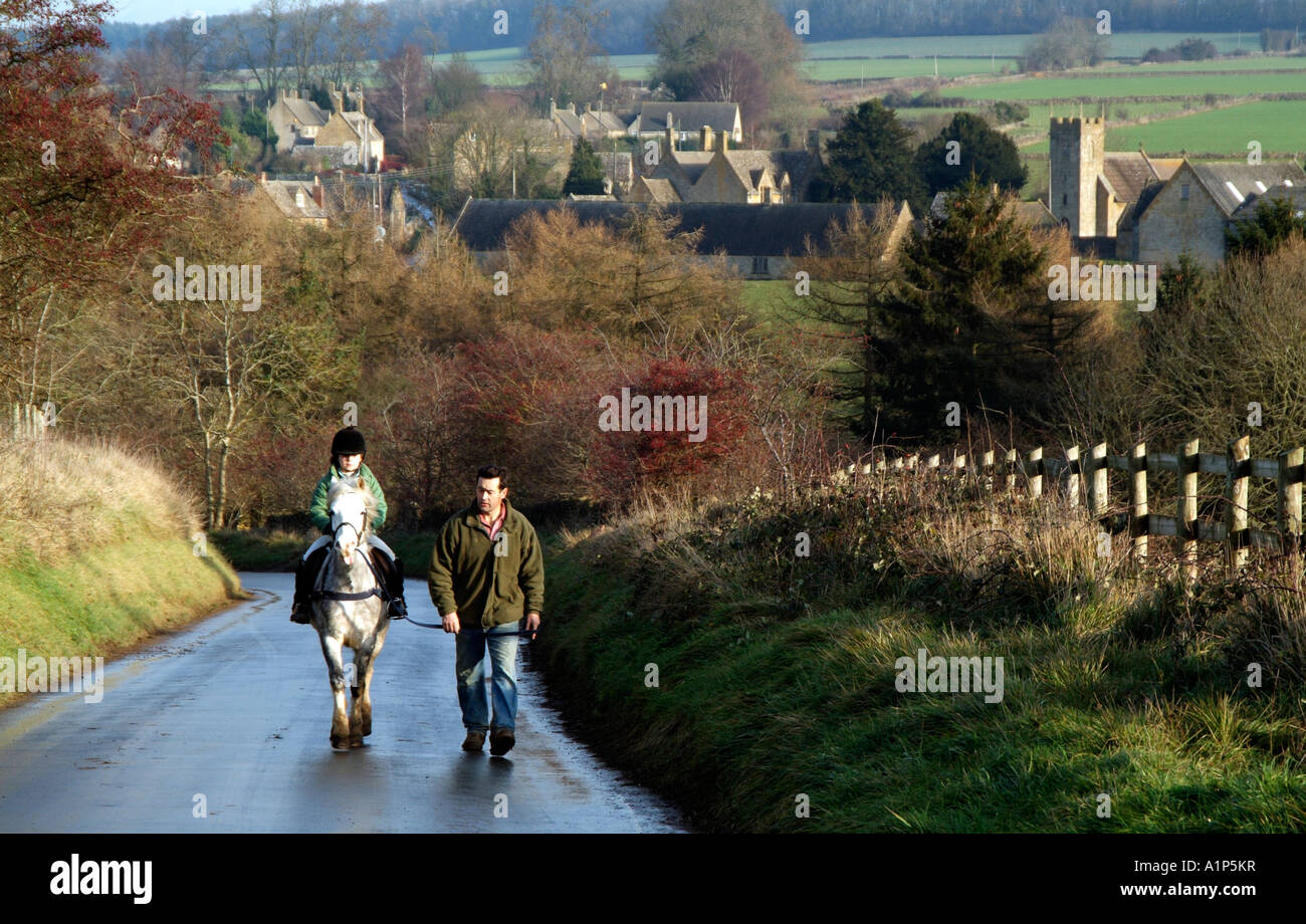 Poney et cavalier sur un rein sur un chemin de campagne dans le nord de la région des Cotswolds Gloucestershire dans la campagne anglaise UK Banque D'Images