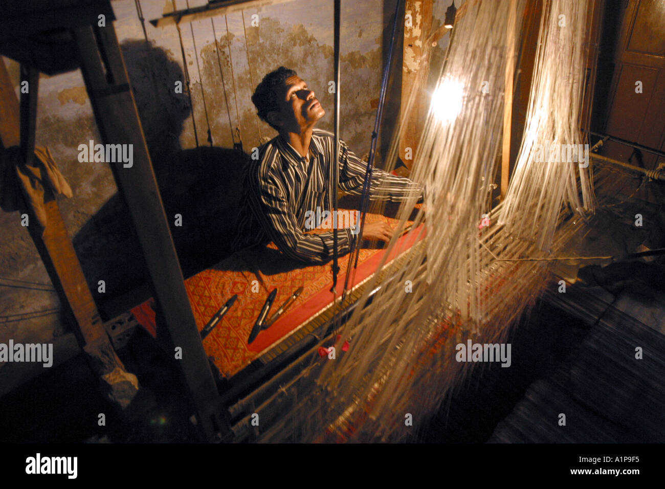 Un tisserand tisse un tapis dans une fabrique de tapis dans la ville de  Varanasi dans le nord de l'Inde Photo Stock - Alamy