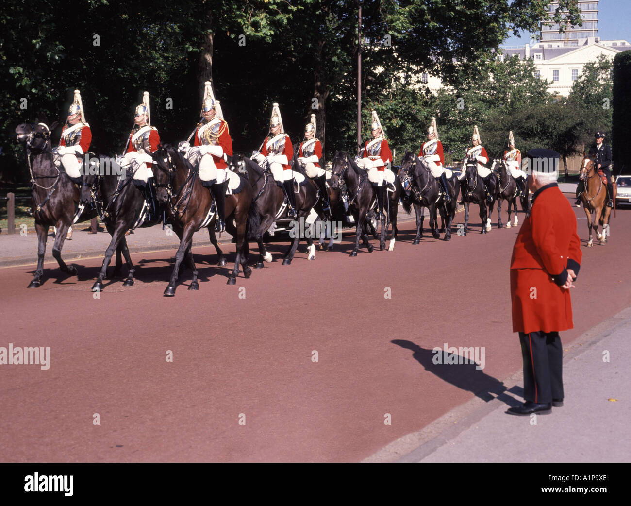Household Cavalry Mounted Regiment Life Guards Troopers arrivant sur le terrain de parade des Horse Guards surveillés par un retraité de Chelsea en uniforme Londres Angleterre Banque D'Images