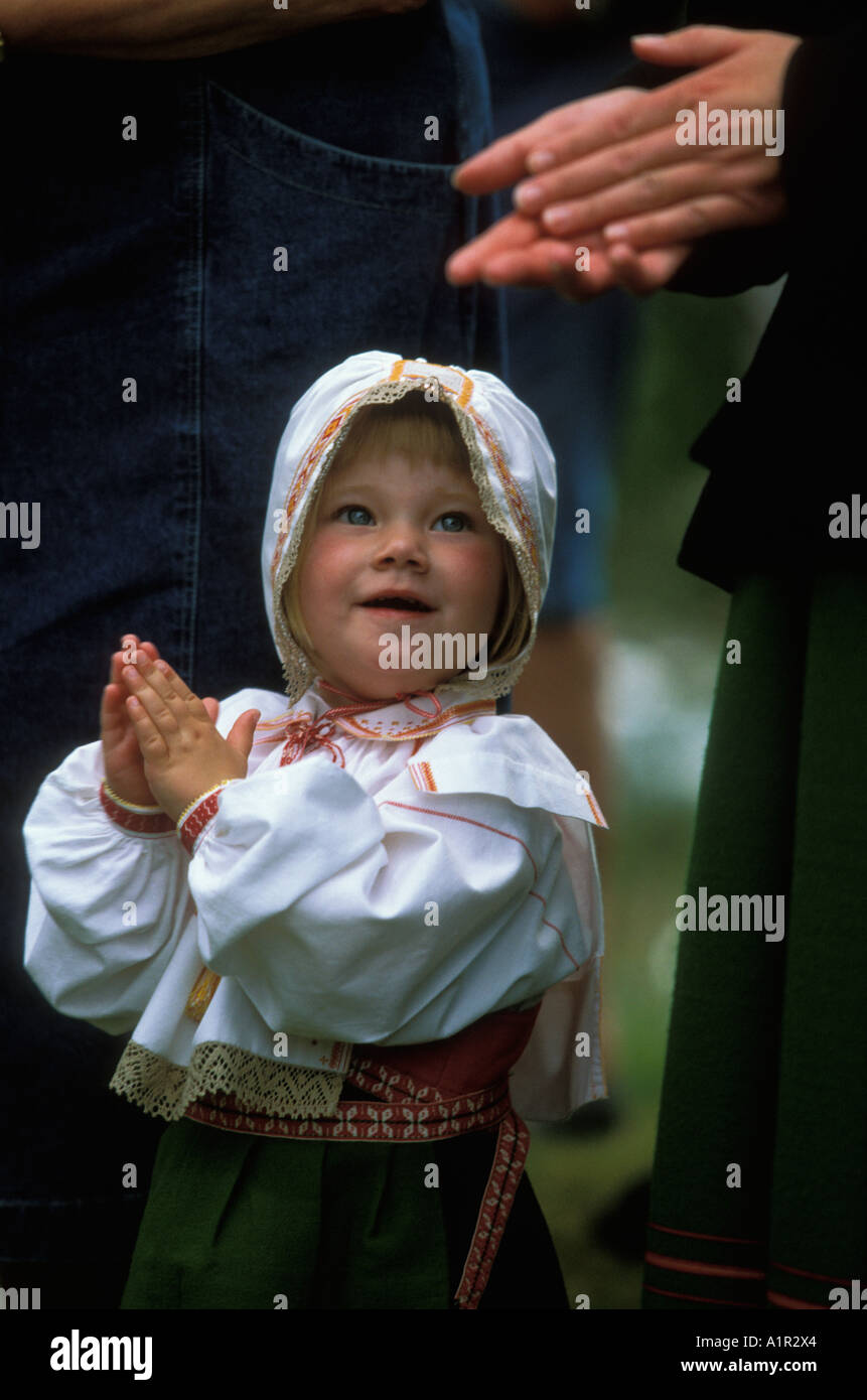 Une jeune fille en costume traditionnel claps ses mains tout en dansant autour du mât en milieu de l'ORSA, dalarna, Suède Dalécarlie ou Banque D'Images