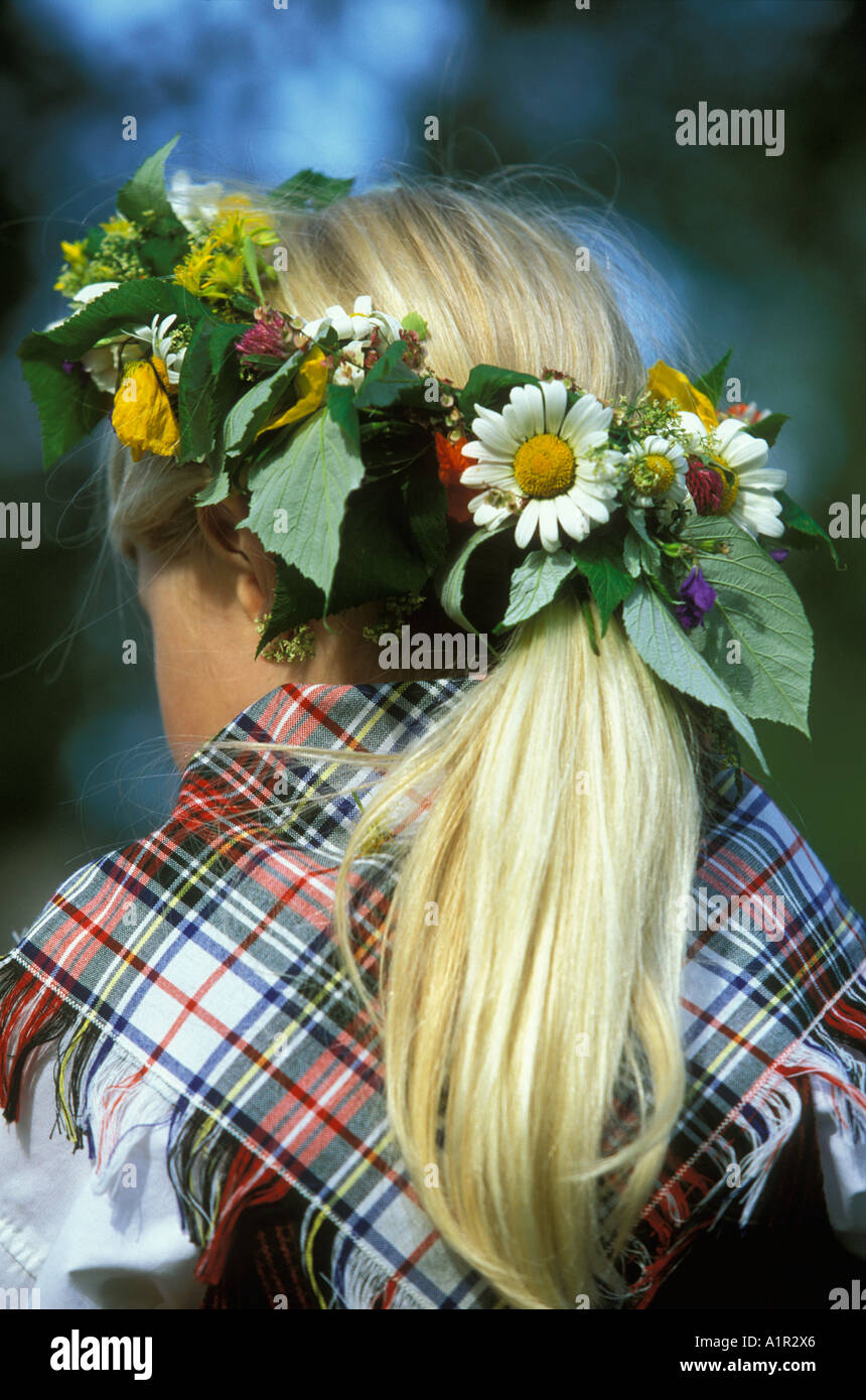 Une jeune fille aux cheveux blonds et une gerbe de fleurs en plein été clebrates Orsa, dalarna, Suède Dalécarlie ou Banque D'Images