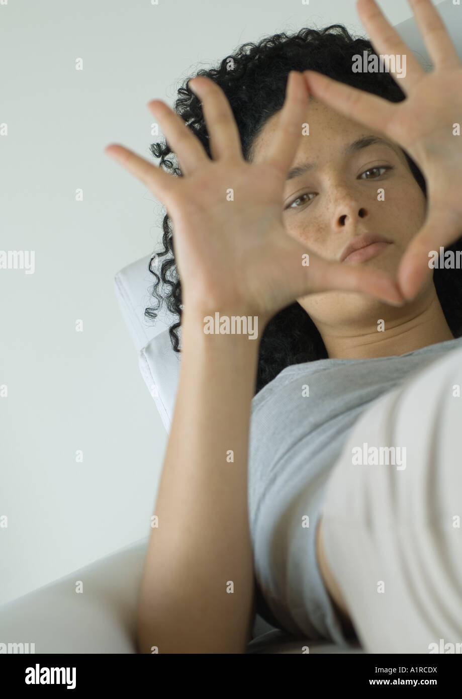 Femme couchée, ce qui cadre avec les mains Banque D'Images