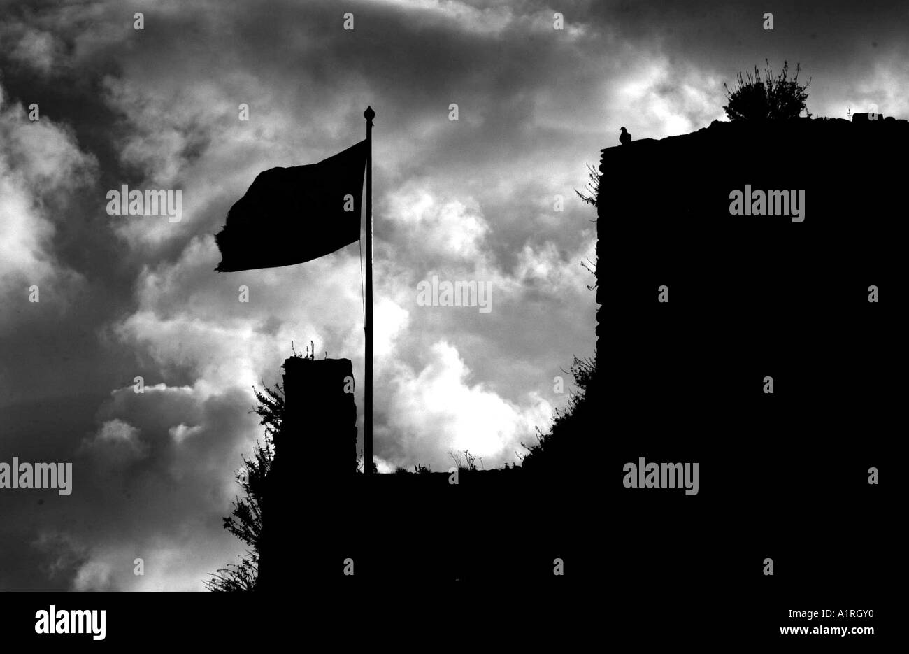 Drapeau sur le toit de mâchicoulis du château d'Oystermouth dans Mumbles, Swansea, Pays de Galles, Royaume-Uni. Banque D'Images