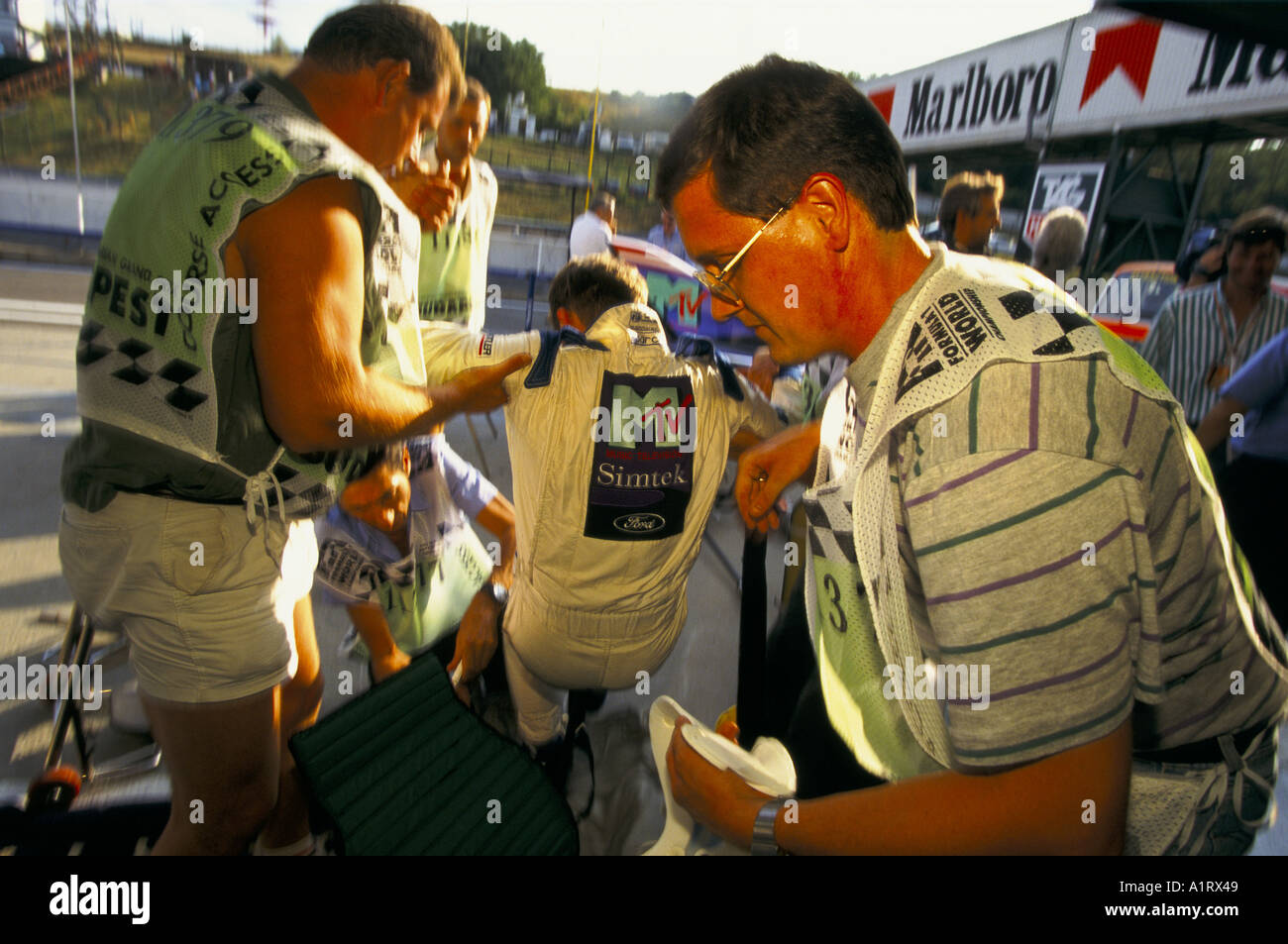 Les MEMBRES DE LA SIMTEK F1 TEAM SOULEVER UN HOMME DANS LA RACE BLANCHE COMBINAISON LORS DU GRAND PRIX DE HONGRIE 1994 Banque D'Images