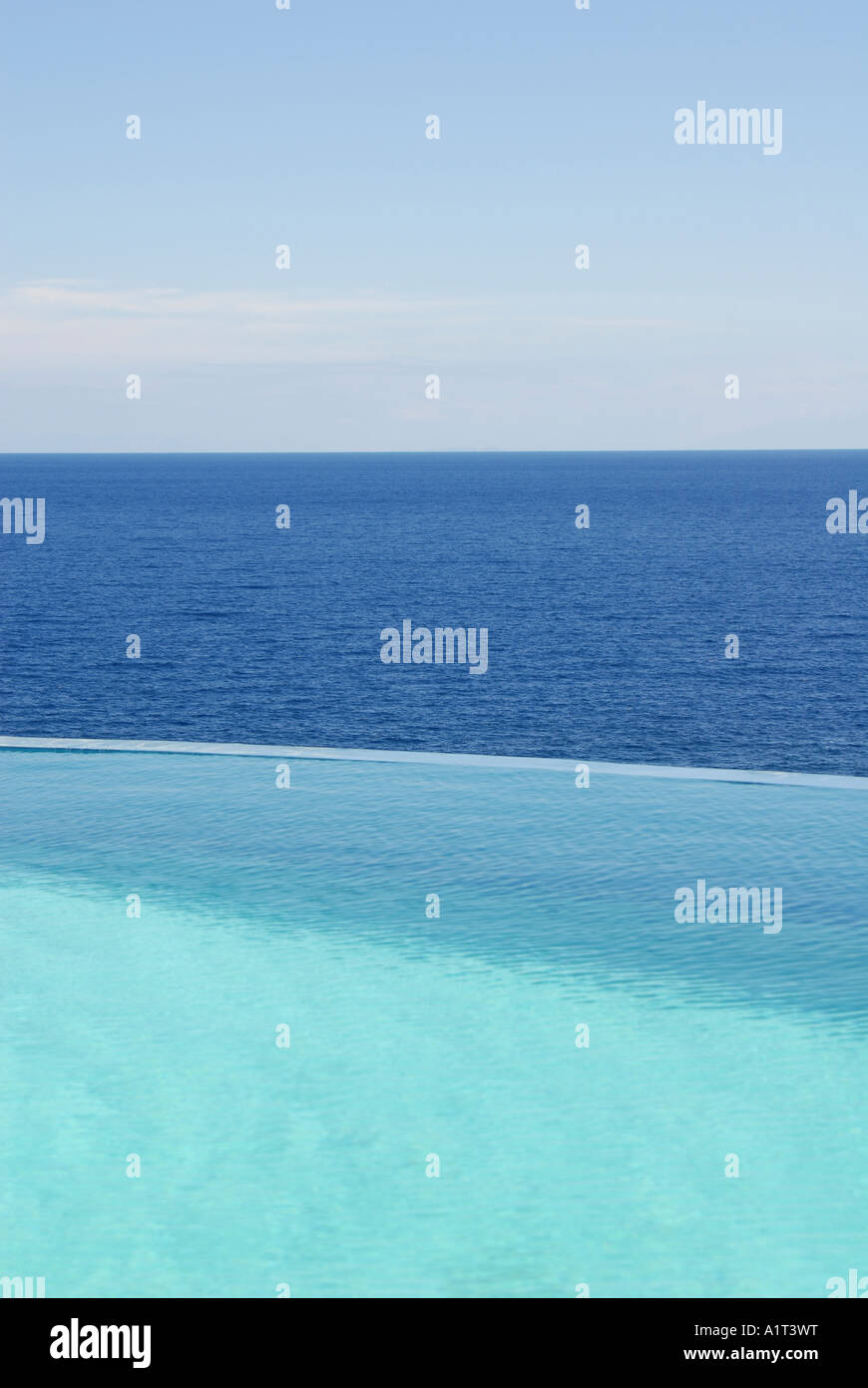 Maison de vacances en plein air piscine à débordement en face de la mer bleue et ciel bleu Banque D'Images