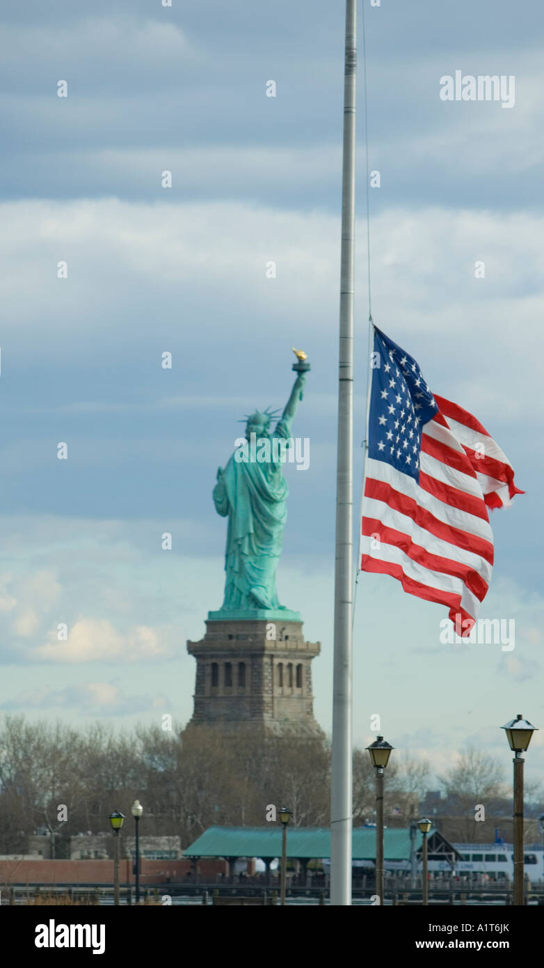 Un drapeau américain en berne avec la Statue de la liberté en arrière-plan Banque D'Images