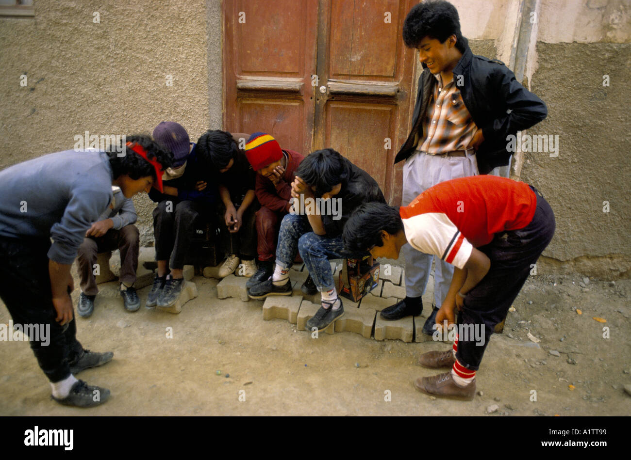 Service de Cireur garçons jouant aux billes dans Street Banque D'Images