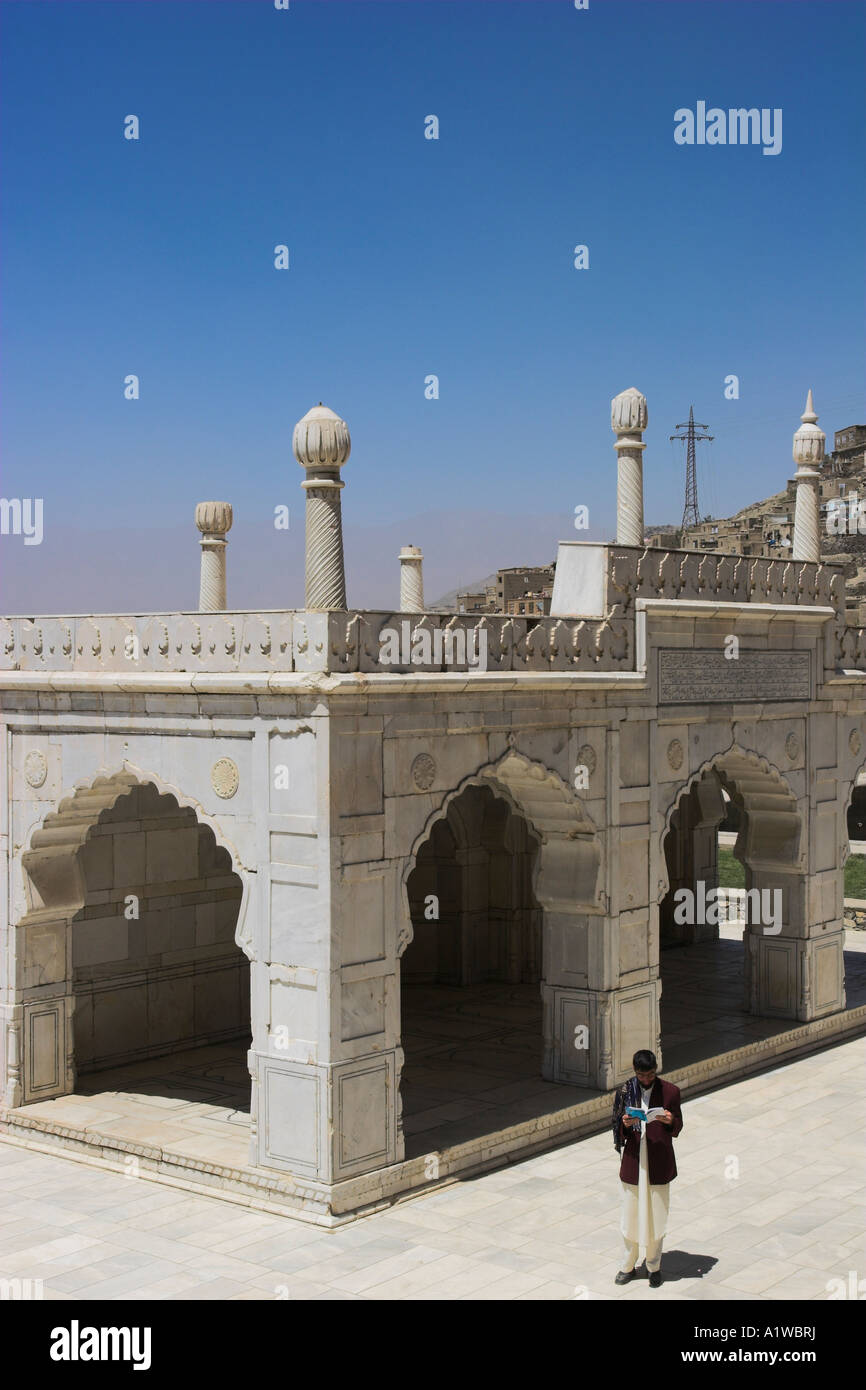 AFGHANISTAN Kaboul Jardins de Babur homme lisant le Coran en marchant autour de la mosquée de marbre blanc construit par Shah Jahan Banque D'Images