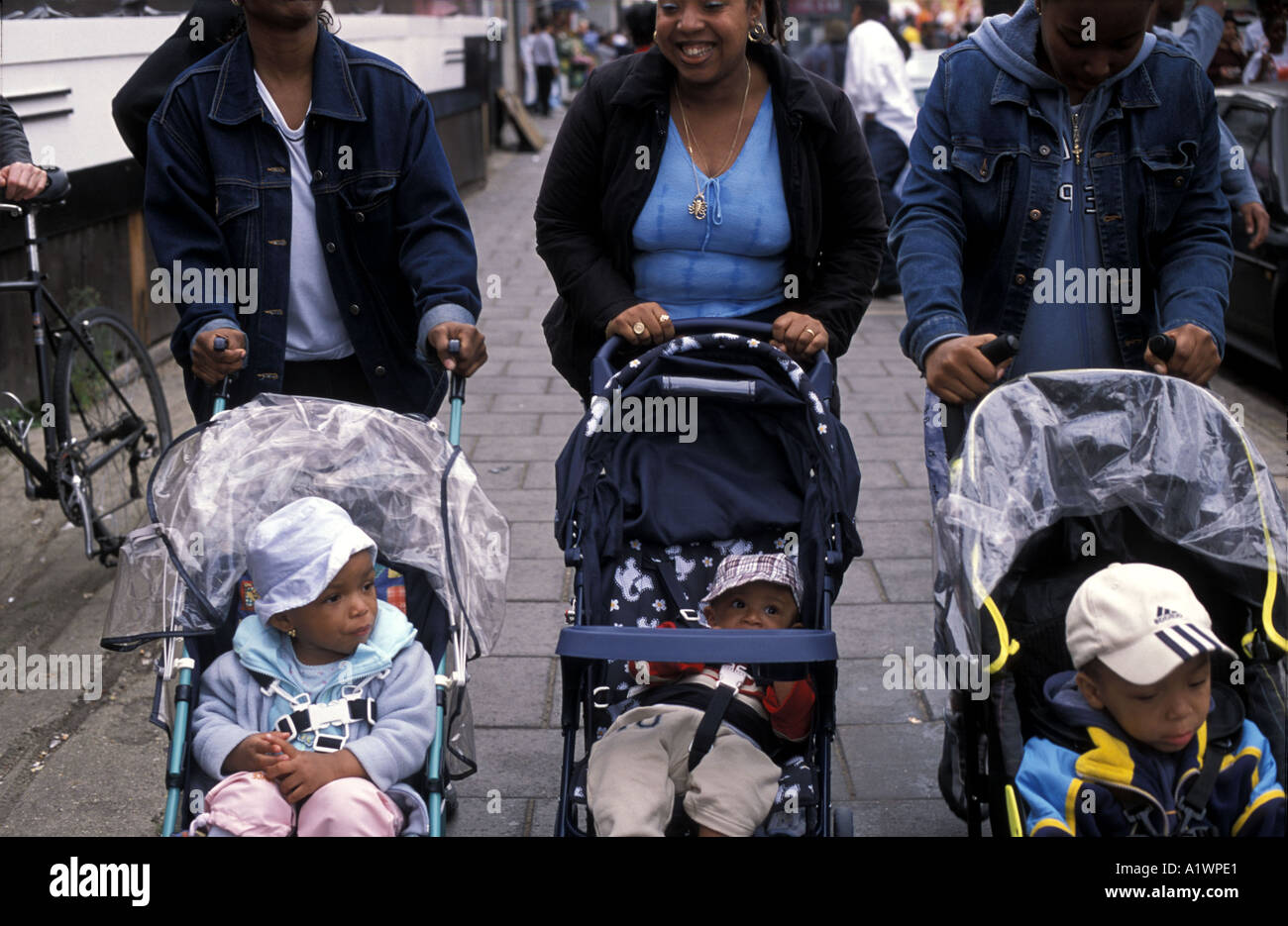 Les jeunes mères afro/Caraïbes pousser leurs bébés en poussette Banque D'Images