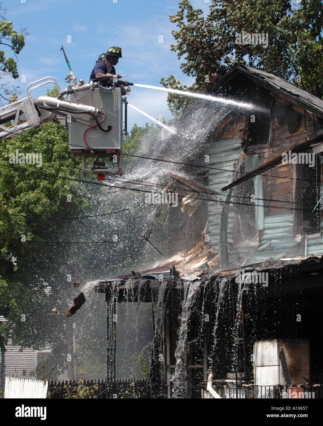 Les pompiers de pulvériser une maison la lutte contre l'incendie un incendie Banque D'Images