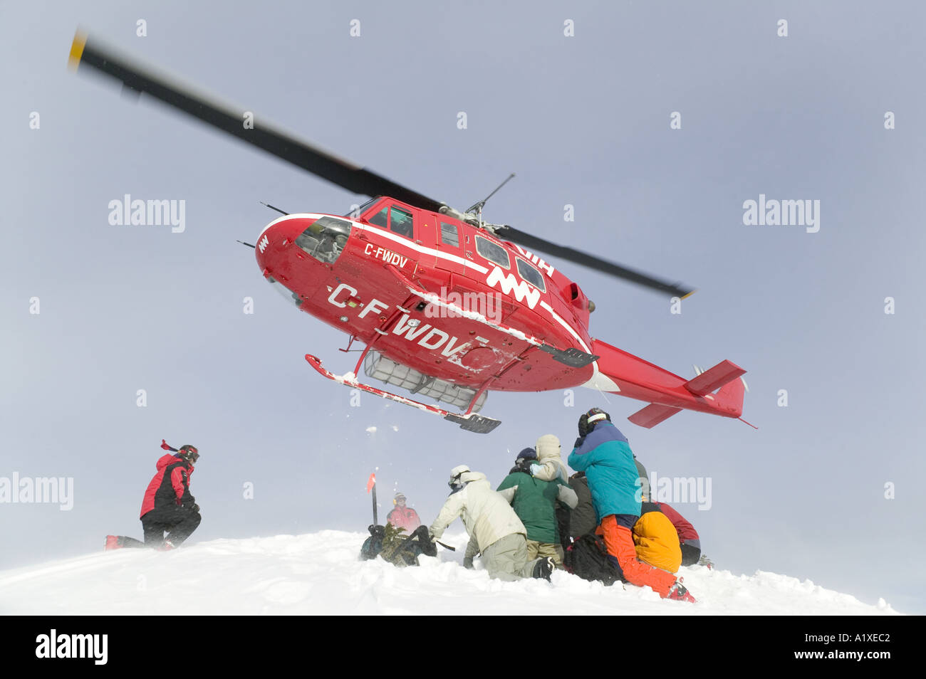 La chute de l'hélicoptère de skieurs et planchistes Banque D'Images