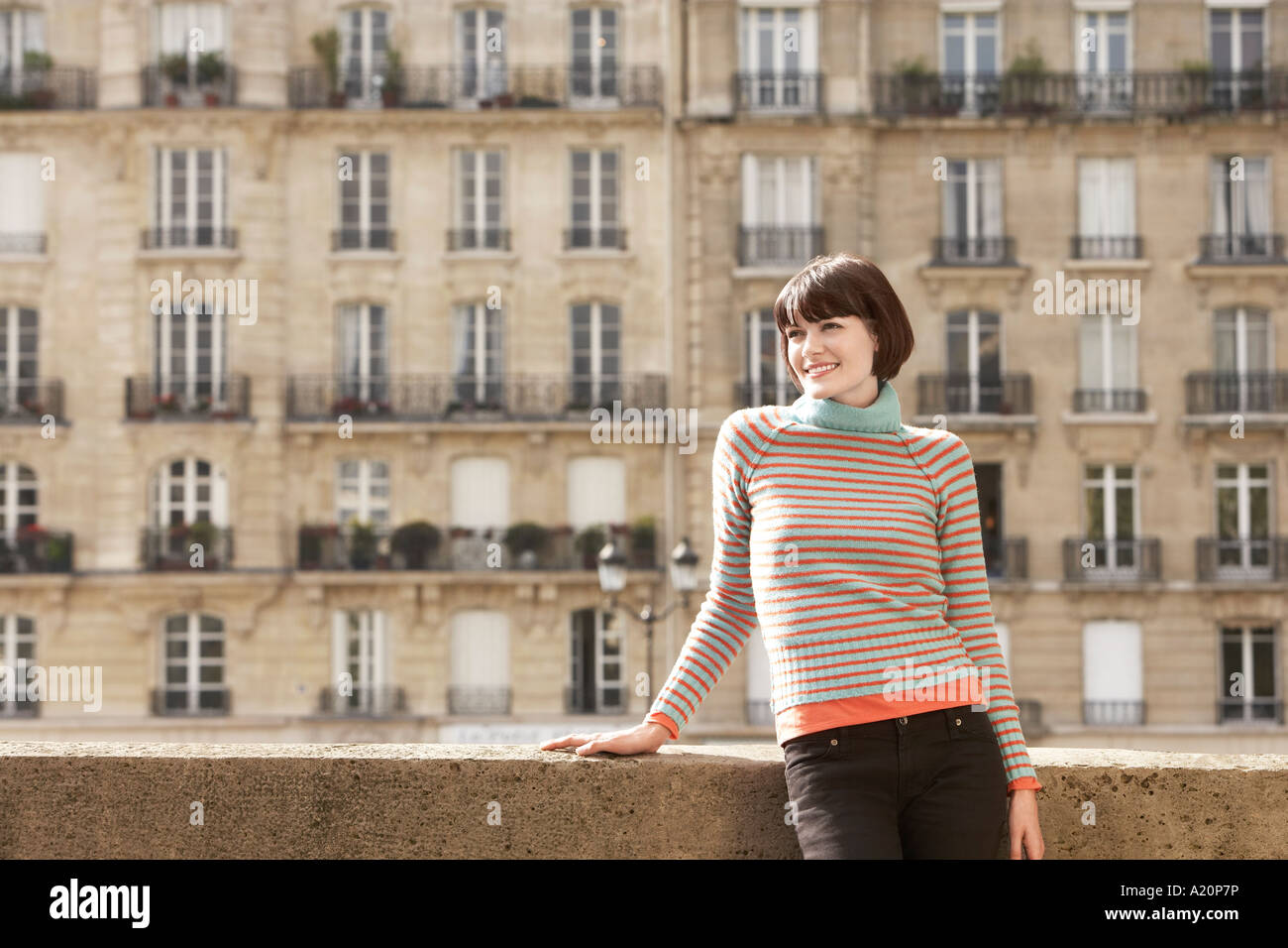 Young woman posing on pont en face de maisons de ville Banque D'Images