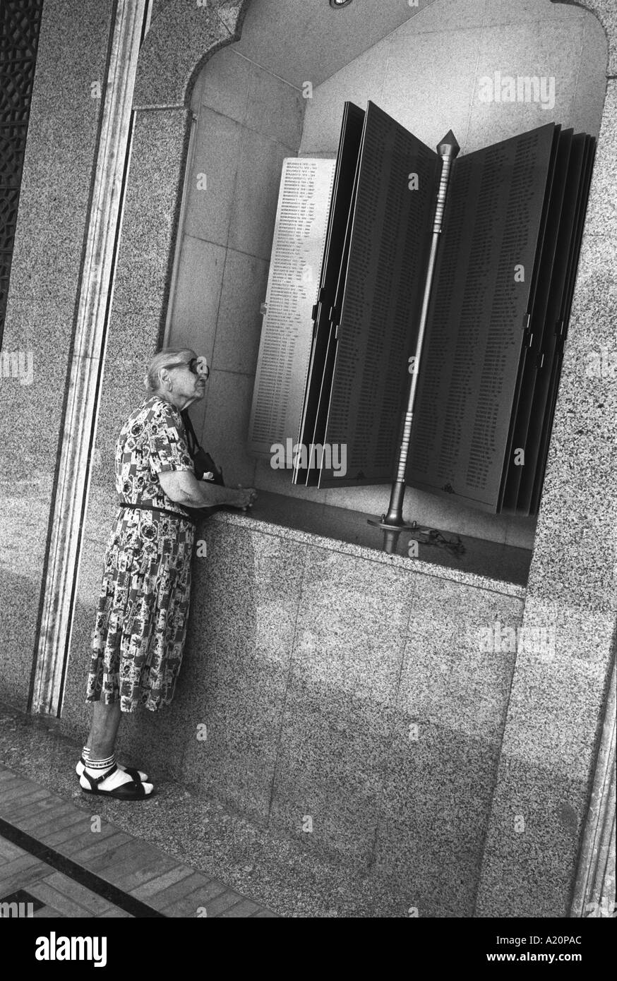 Femme ouzbek se lit le nom des morts de la guerre d'un monument commémoratif de la Seconde Guerre mondiale au cours de la fête de la Victoire à Tachkent, Ouzbékistan Banque D'Images