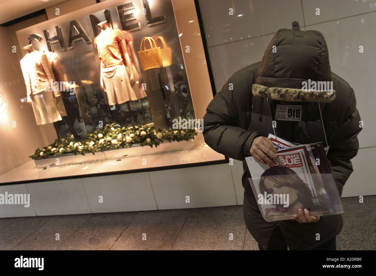 L'homme sans-abri japonais vendent le gros problème en face de magasin Chanel mode, Tokyo, Japon. Banque D'Images