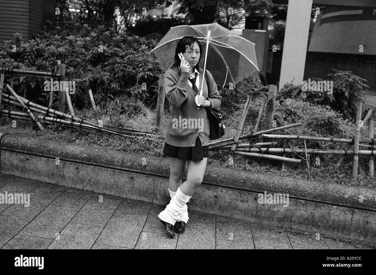 L'école japonaise fille parlant sur son téléphone mobile, Tokyo, Japon. Banque D'Images