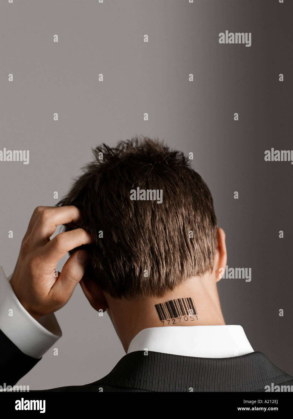 Jeune homme avec code barre tatouage sur son cou, se grattant la tête, vue de dos Banque D'Images