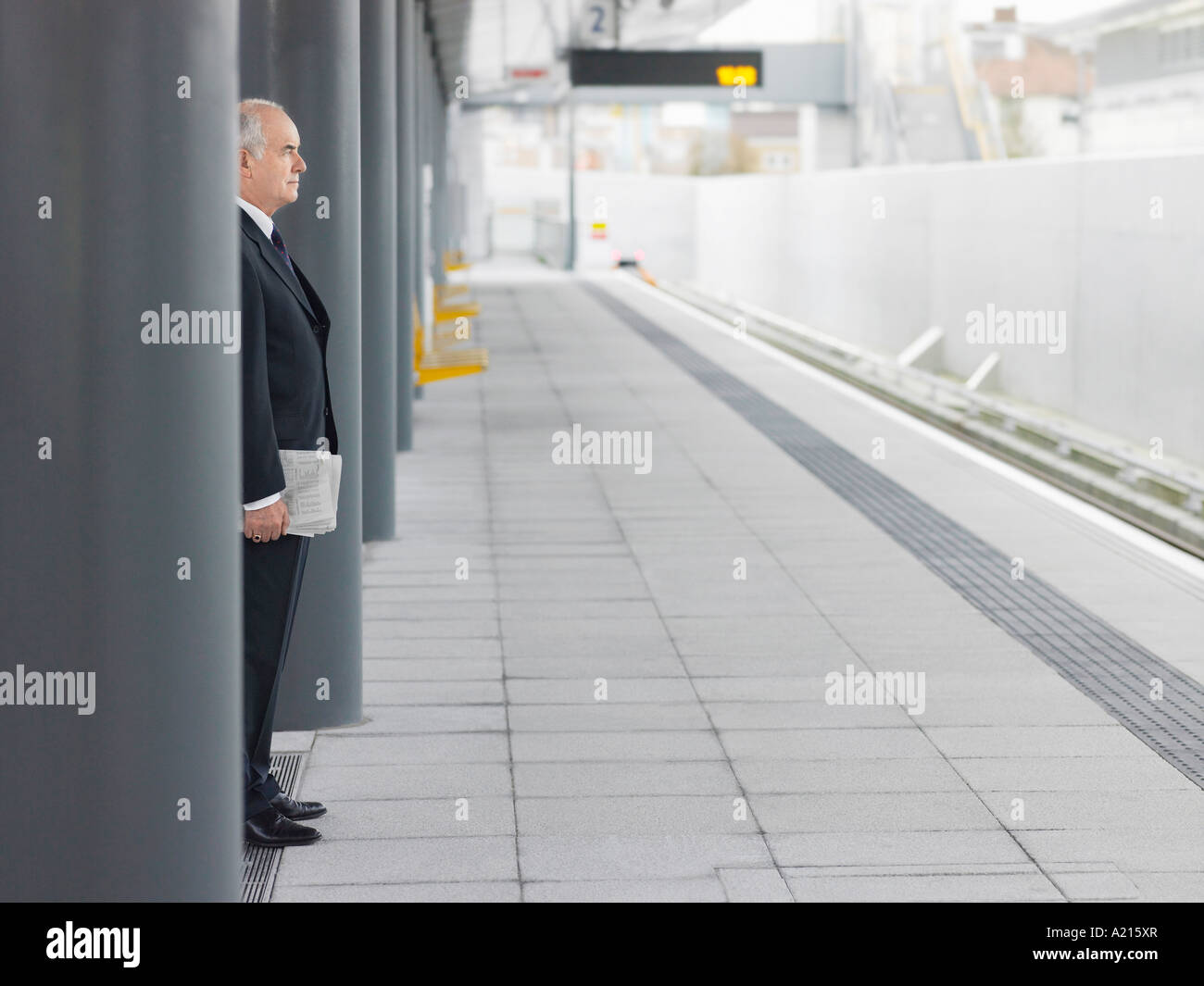 Businessman standing vide, attendant à la Gare, Vue de côté Banque D'Images