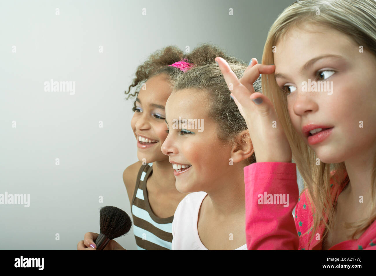 Les filles côte à côte en mettant sur le maquillage, les cheveux de fixation Banque D'Images