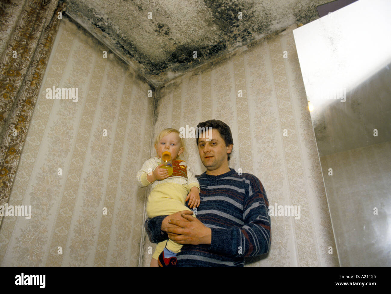 Un père et son enfant forcés de vivre dans une seule chambre à cause de l'humidité dans toutes les autres chambres, Tower Hamlets, London, UK Banque D'Images