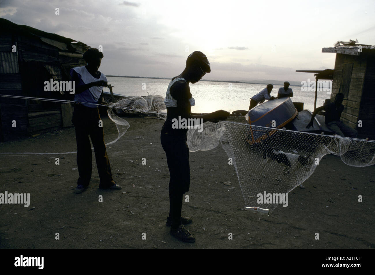 Les pêcheurs préparer un filet de pêche par la mer. Kingston, Jamaïque, Caraïbes Banque D'Images