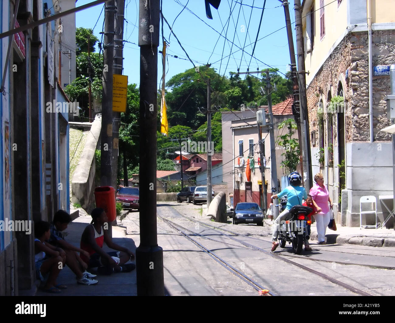 People riding motorbike down street avec les lignes de tram, Santa Teresa, Rio de Janeiro, Brésil Banque D'Images