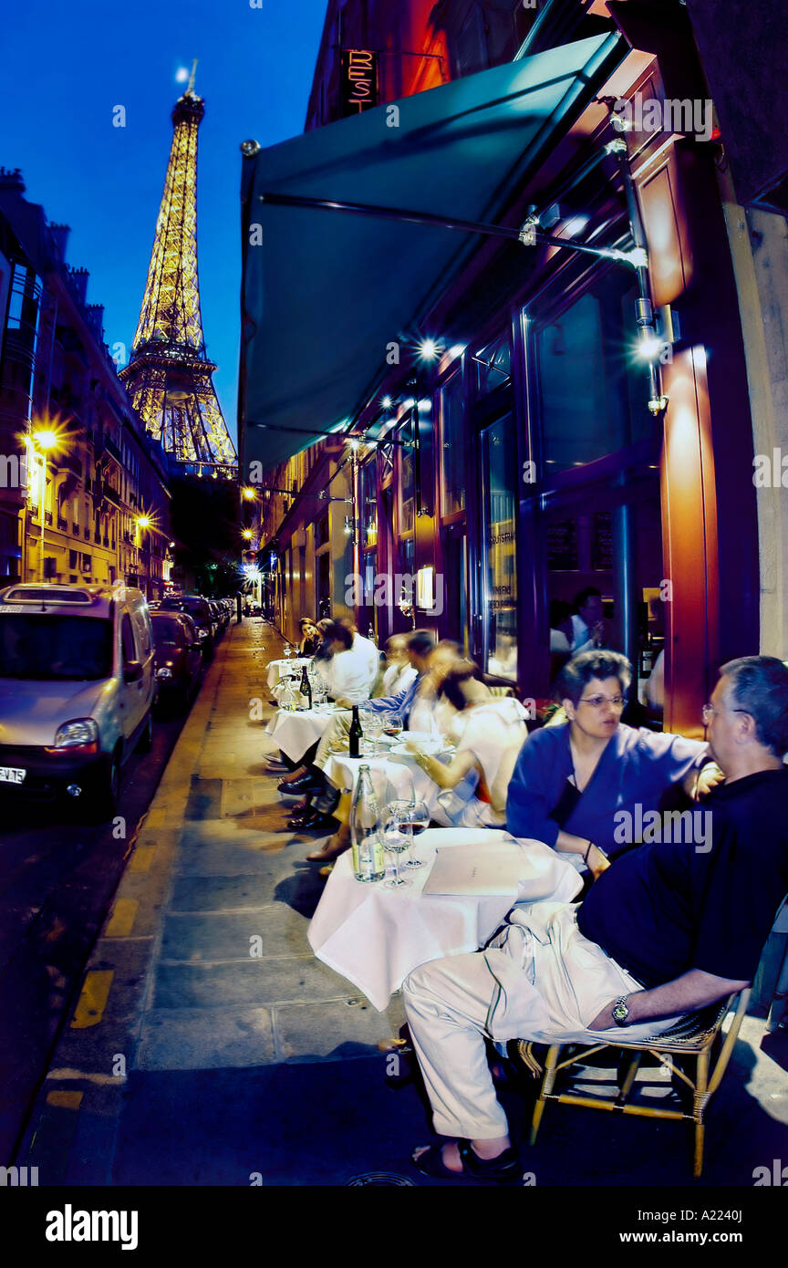 Paris romantique France, couple touristique américain sur le trottoir terrasse du Bistro Restaurant français 'au bon Accueil' près de la Tour Eiffel en terasse de nuit Banque D'Images