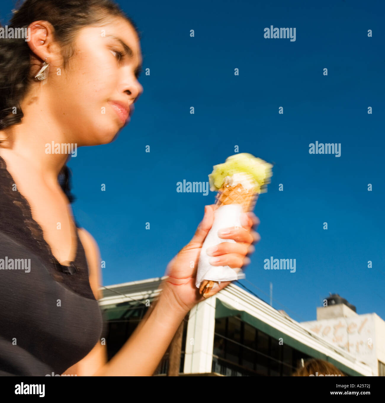 Fille passe dans un flou de manger de la glace sur les rues du centre-ville de Mazatlan Mexique Banque D'Images