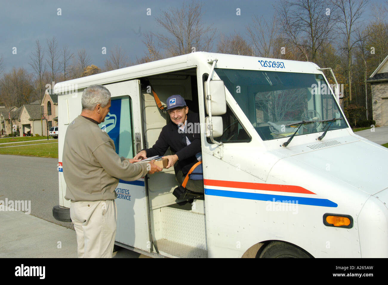 Transporteur Postal conduire un camion postal mail offre aux propriétaires de maison Banque D'Images