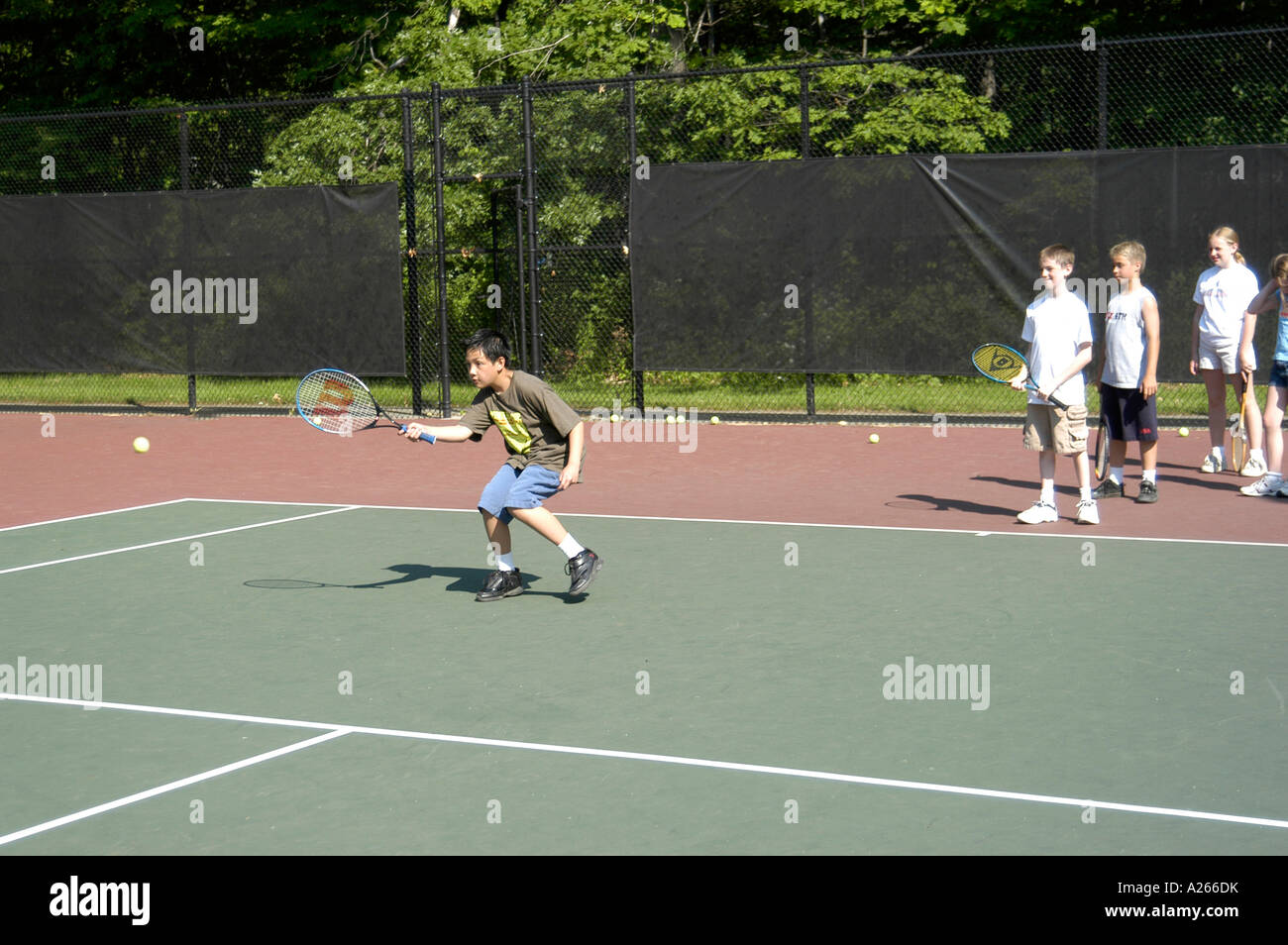 Les leçons de tennis sont fournis par une municipalité locale pour aider les enfants à apprendre la partie de tennis Banque D'Images