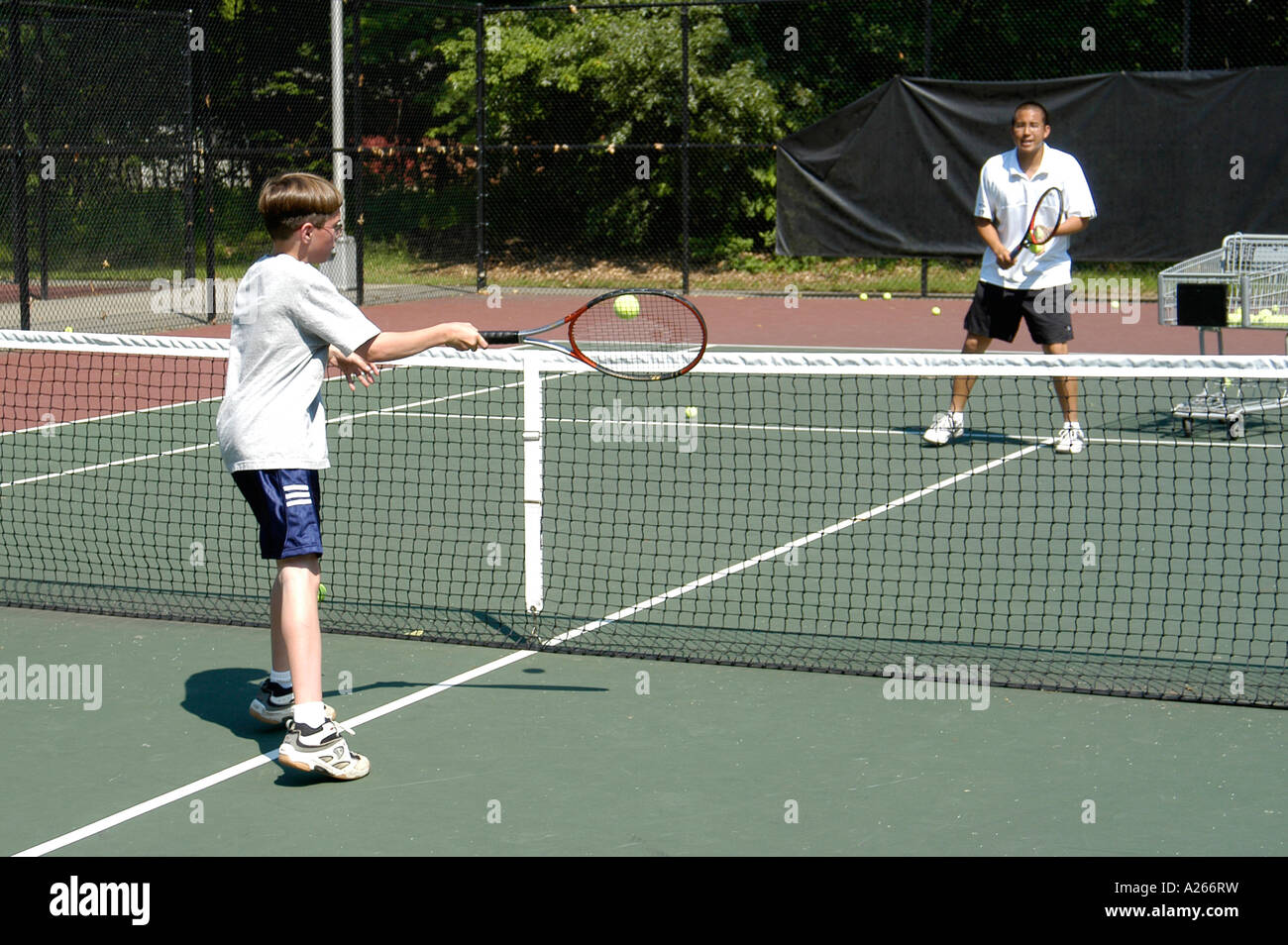 Les leçons de tennis sont fournis par une municipalité locale pour aider les enfants à apprendre la partie de tennis Banque D'Images