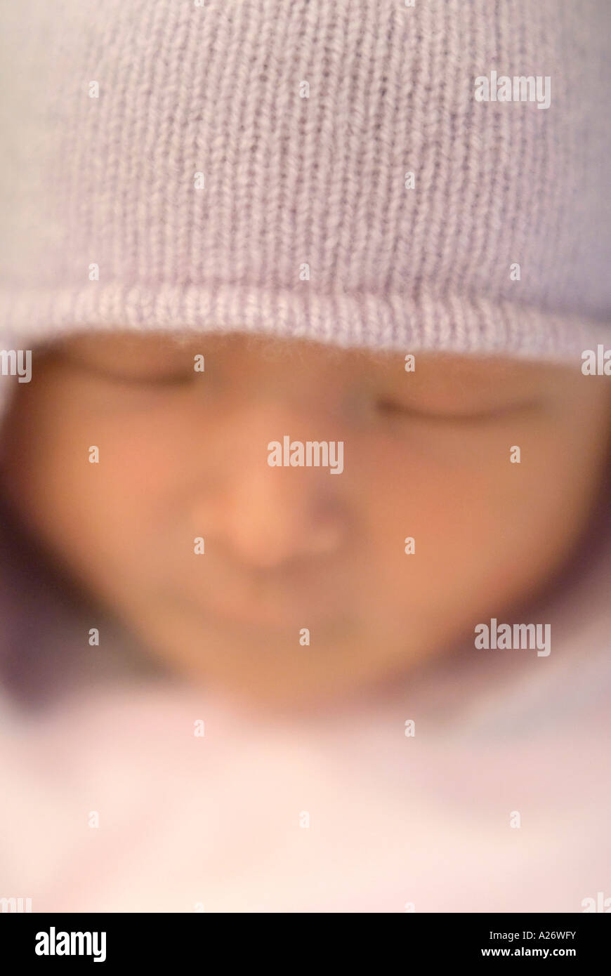 Visage de bébé nouveau-né avec bonnet 3 jours Sleepy éclat rayonnant avec soft focus intentionnellement Banque D'Images
