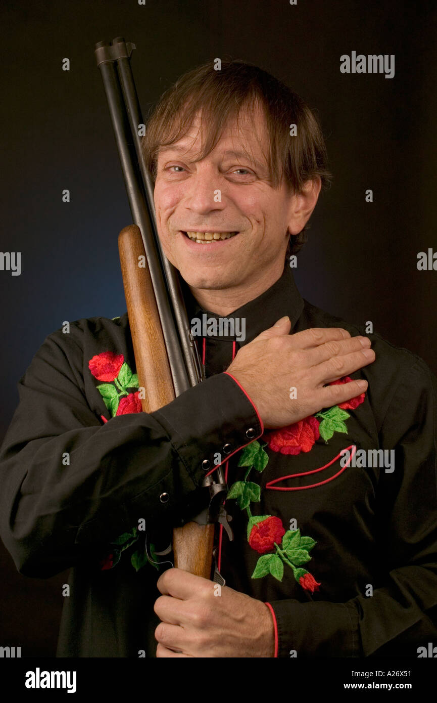 Homme avec bec-de-menton en noir avec chemise western carabine Savage Banque D'Images