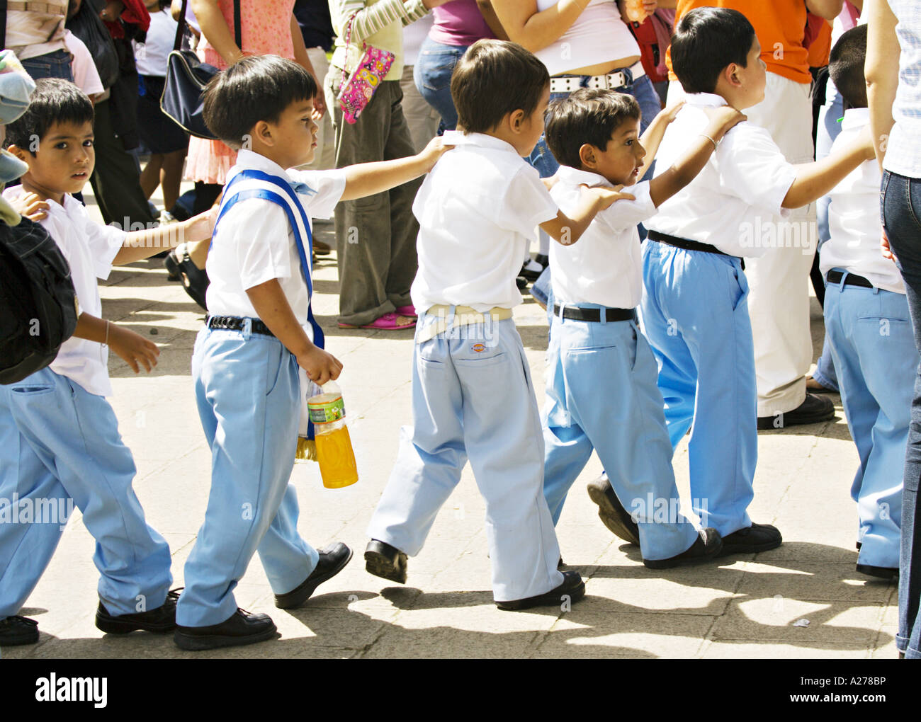 GUATEMALA ANTIGUA écoliers en uniforme sur le terrain pour l'indépendance jour tenir mutuellement les épaules comme s'ils marchent Banque D'Images