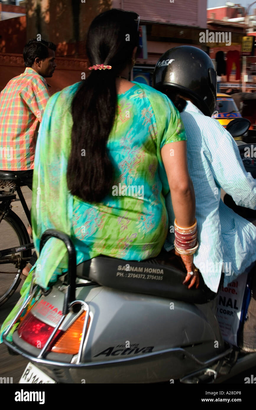 Le RSC76735 très grosses femmes aux cheveux longs en robe vert sitiing sur le siège arrière d'un scooter Banque D'Images