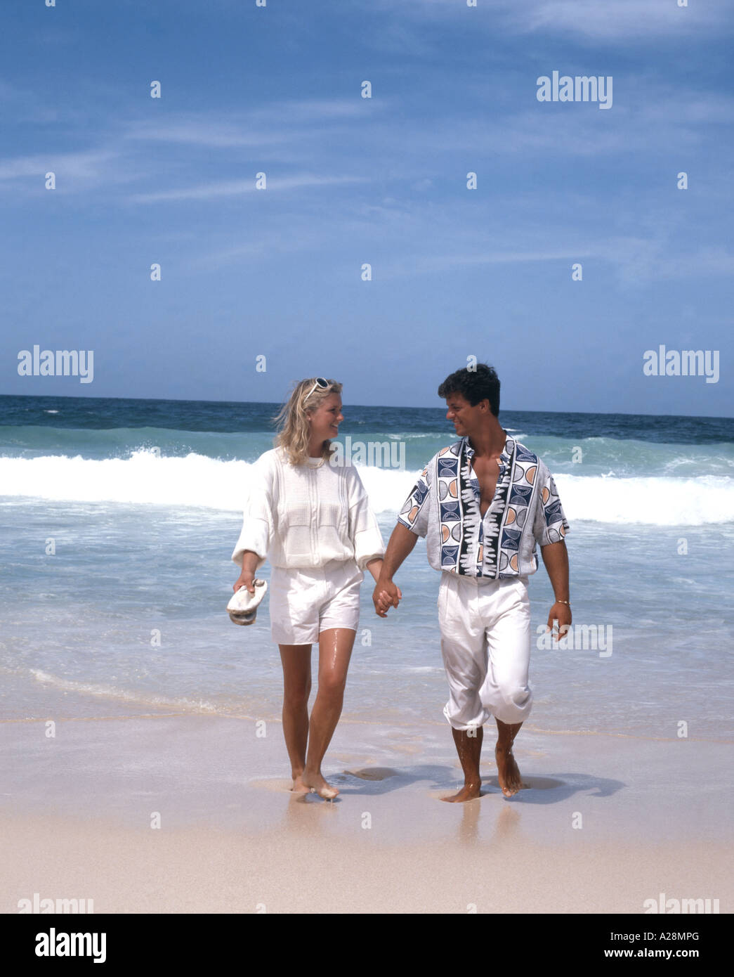 Couple walking on tropical beach, plage de Grand'Anse, l'île de La Digue, République des Seychelles Banque D'Images