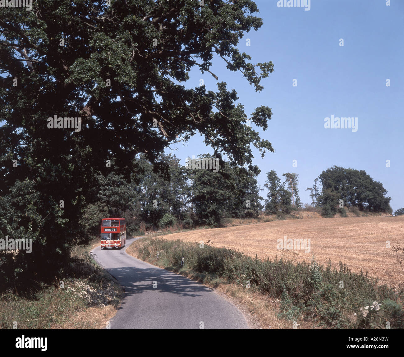 Red bus on country road, Suffolk, Angleterre, Royaume-Uni Banque D'Images