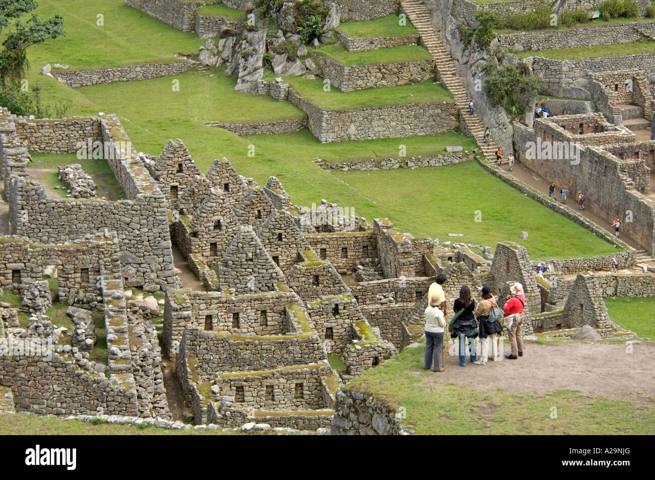 Un groupe de touristes à l'ancien site Inca de Machu Picchu au Pérou. Banque D'Images