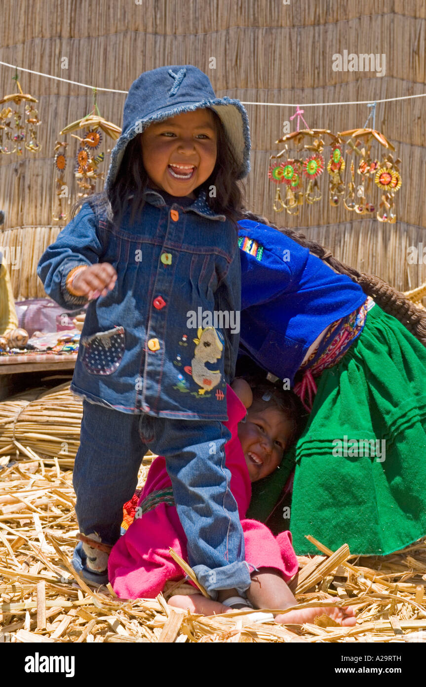 Les enfants sur une des îles du lac Titicaca, reed jouant et riant pose devant l'appareil photo. Banque D'Images