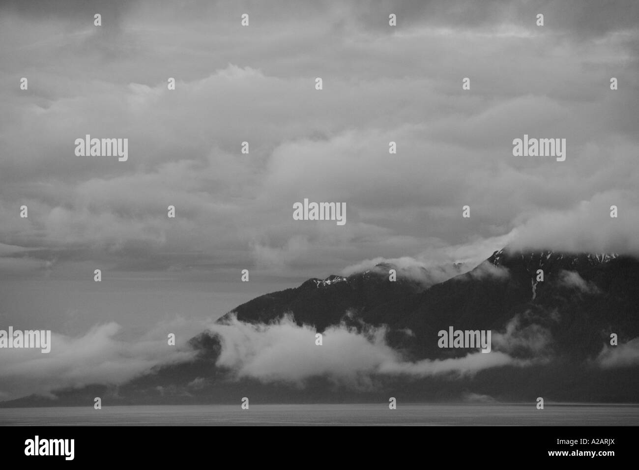 B/w Alaskan montagnes enveloppées de nuages en soirée Banque D'Images