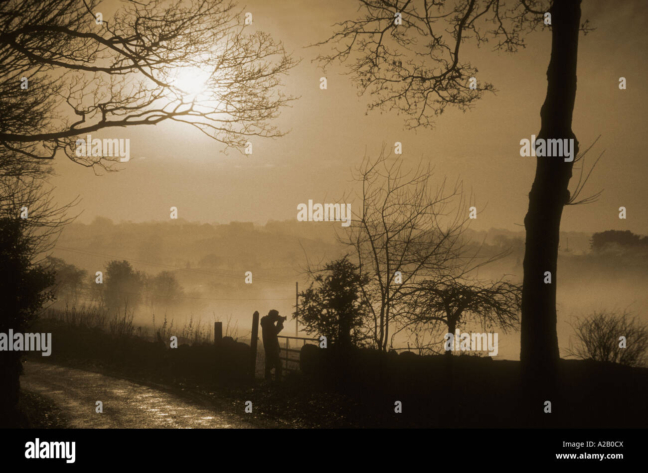 Silhouette d'un photographe, la prise de photos, d'un paysage brumeux Staffordshire. Banque D'Images