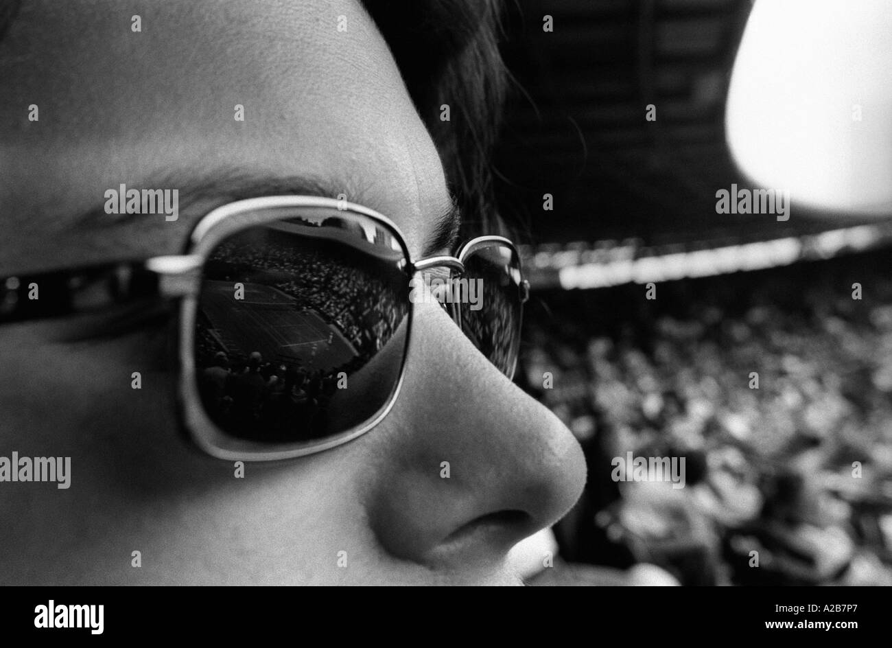 Une fille en lunettes de soleil dans la foule à un tournoi de tennis Banque D'Images