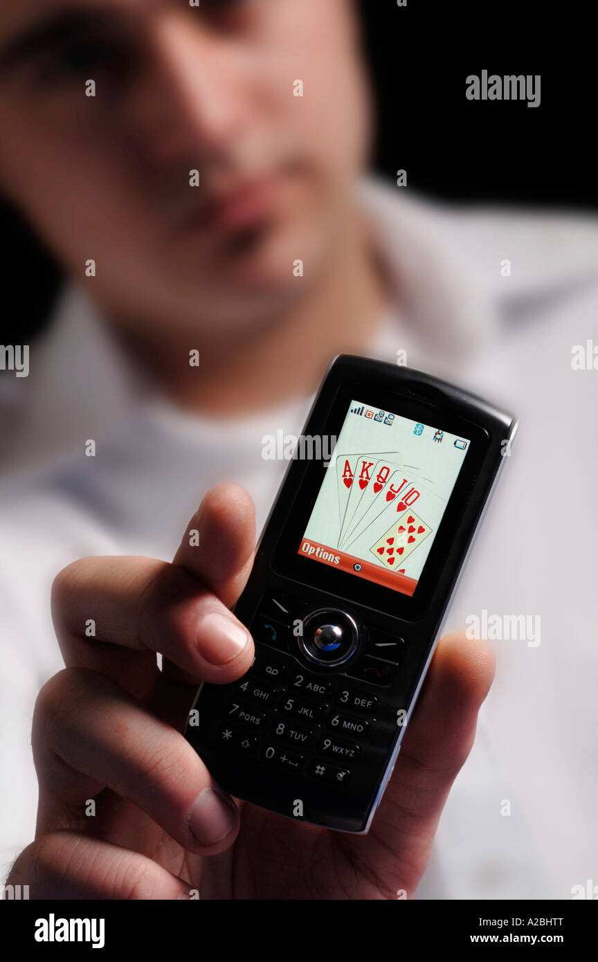 Jeune homme montrant royal flush sur téléphone mobile Banque D'Images